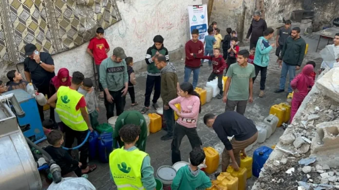 Gaza residents line up to collect water from Namaa Charity trucks