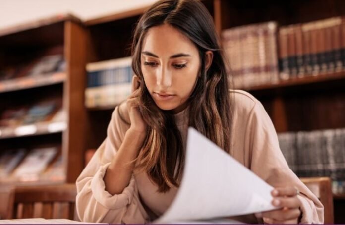 A woman holding a paper to represent MENA Junior Fellowship Program