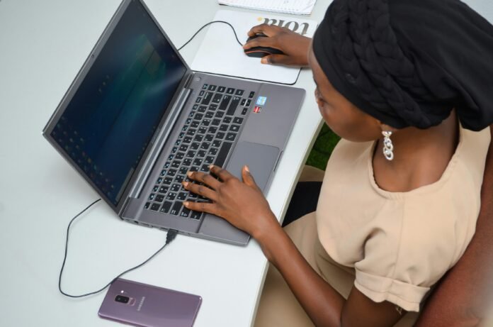 A woman sitting at a desk with laptop to represent Advancing Digital Rights and Youth Participation
