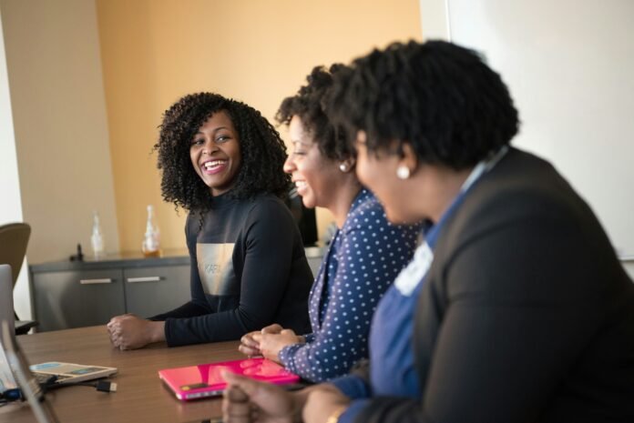 A group of women sitting and smiling to represent AfNet Flexible Grant 2026