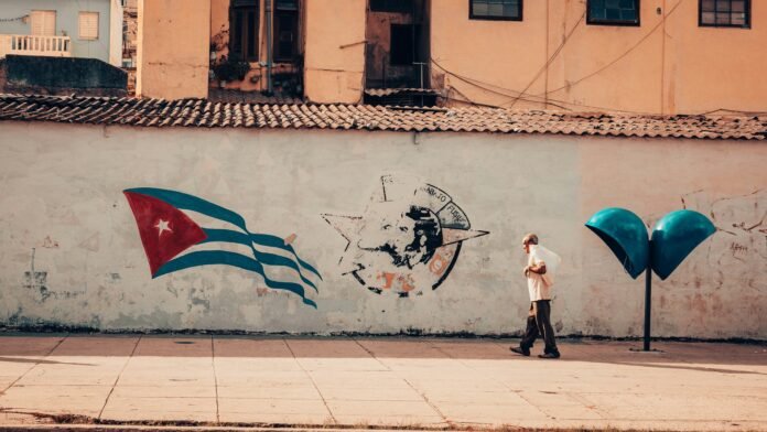 Man walks to Cuba flag on wall aid
