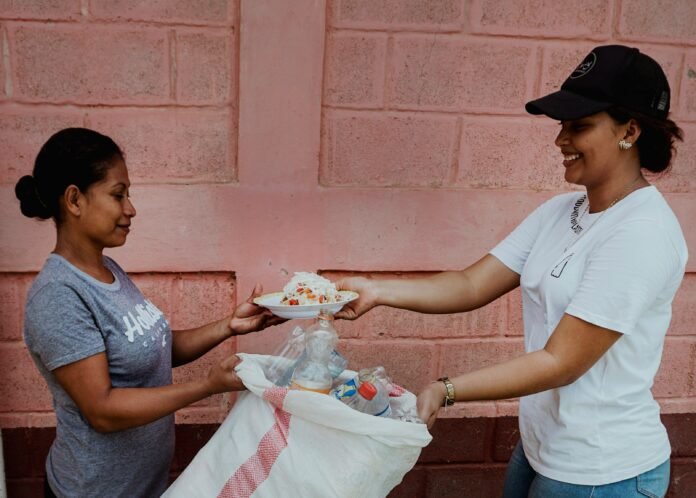 A woman handing out food to another woman to represent Joseph and Vera Long Foundation Grant 2026