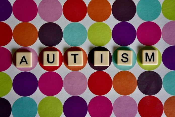 Autism word spelled out with scrabble tiles as Catalight and Cognoa ink partnership