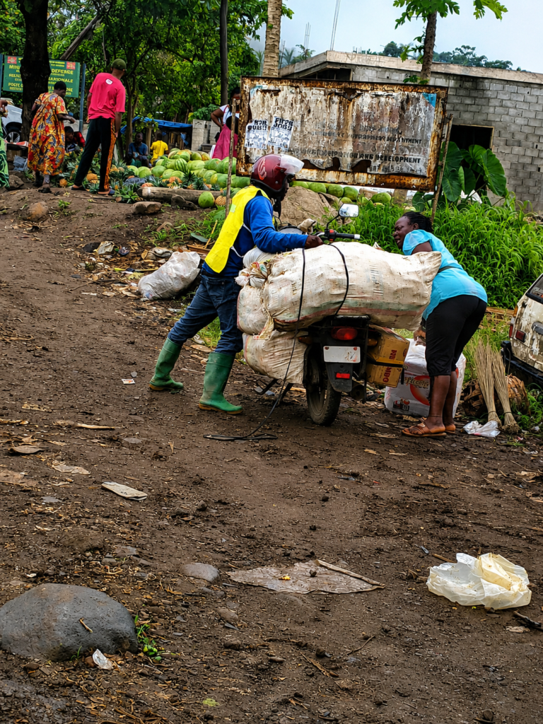 woman and man load farm produce to a motorcycle